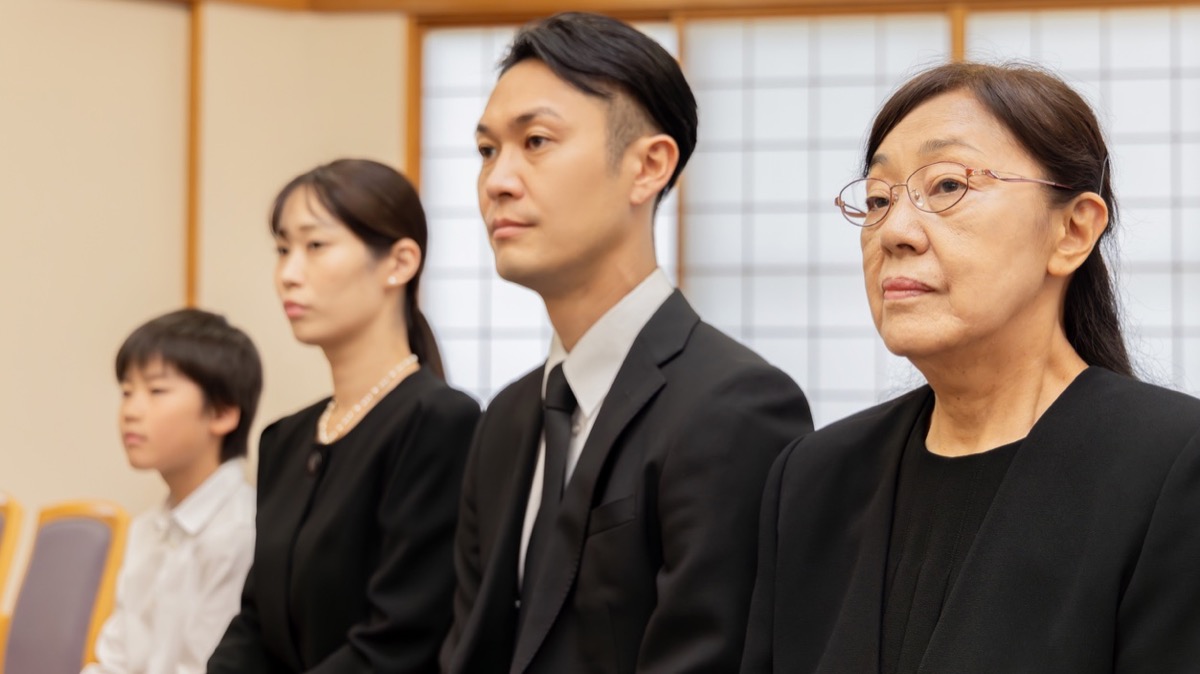 喪服を着て葬儀に参列する家族