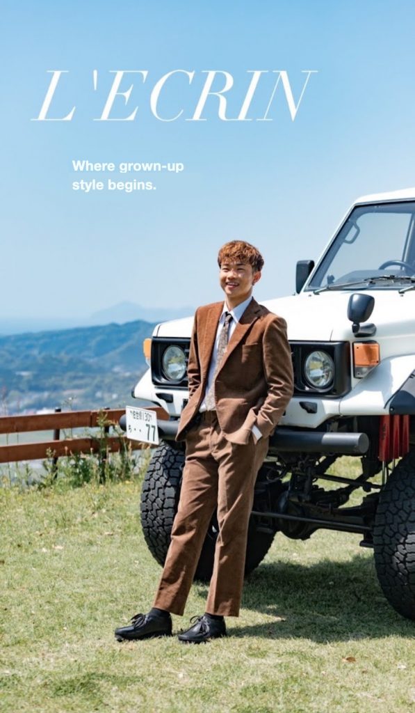 A brown corduroy suit worn in front of a four-wheel-drive vehicle on a hilltop
